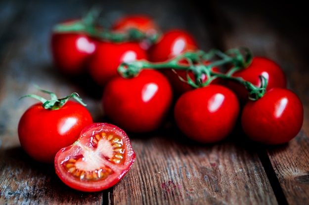 Tomatoes on the vine on rustic wooden background